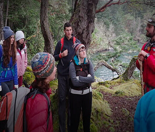 Instructor teaching about plant ecology in the forest